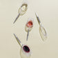 4 Crystal Wine Glasses with metal pins, half-filled with wine, laying