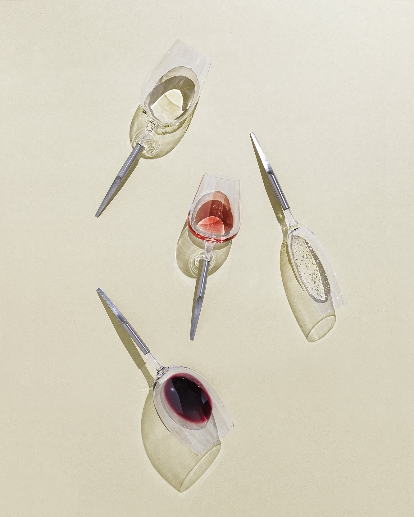 4 Crystal Wine Glasses with metal pins, half-filled with wine, laying