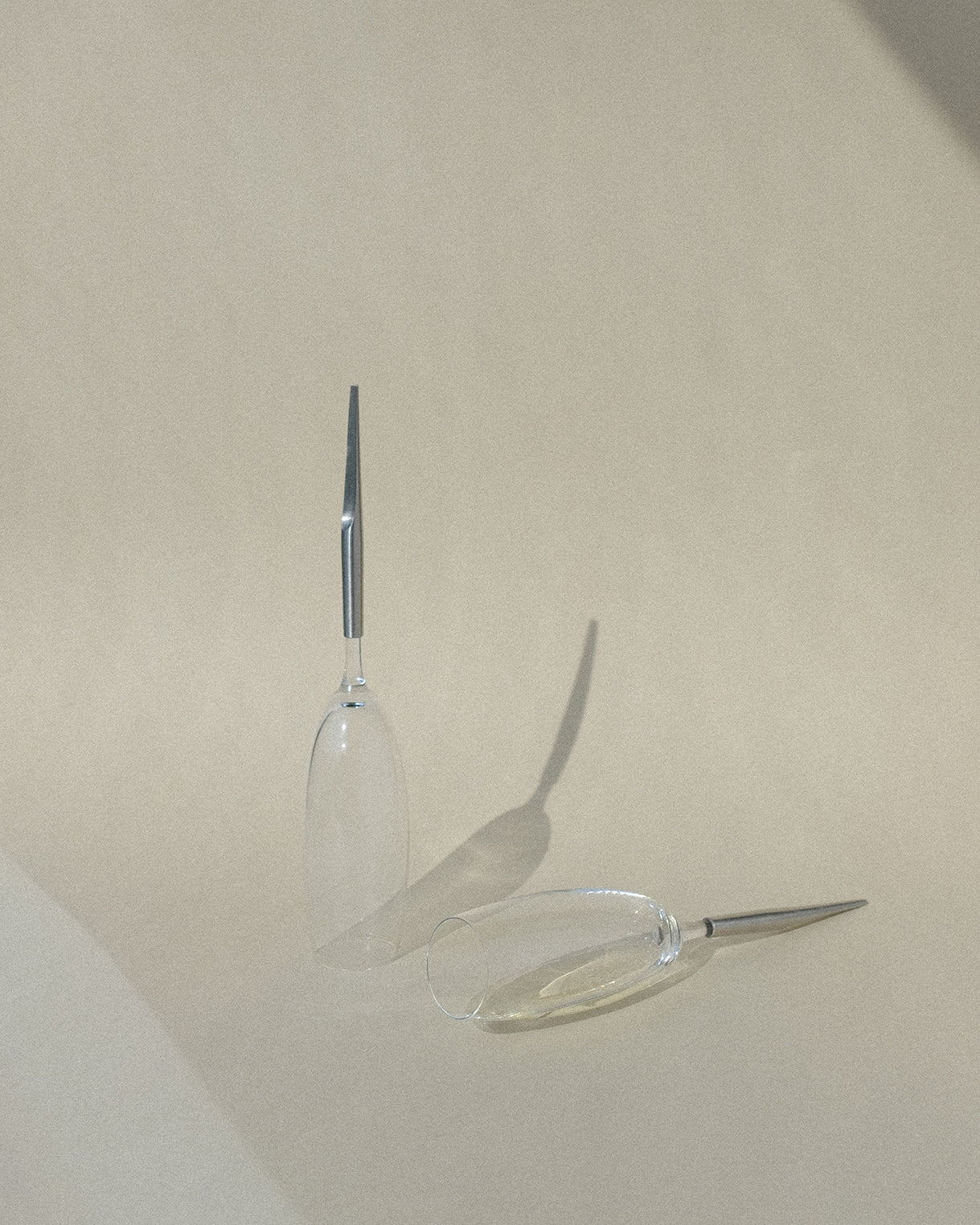 2 Crystal Champagne Glasses with metal Pin, one laying and one standing upside-down