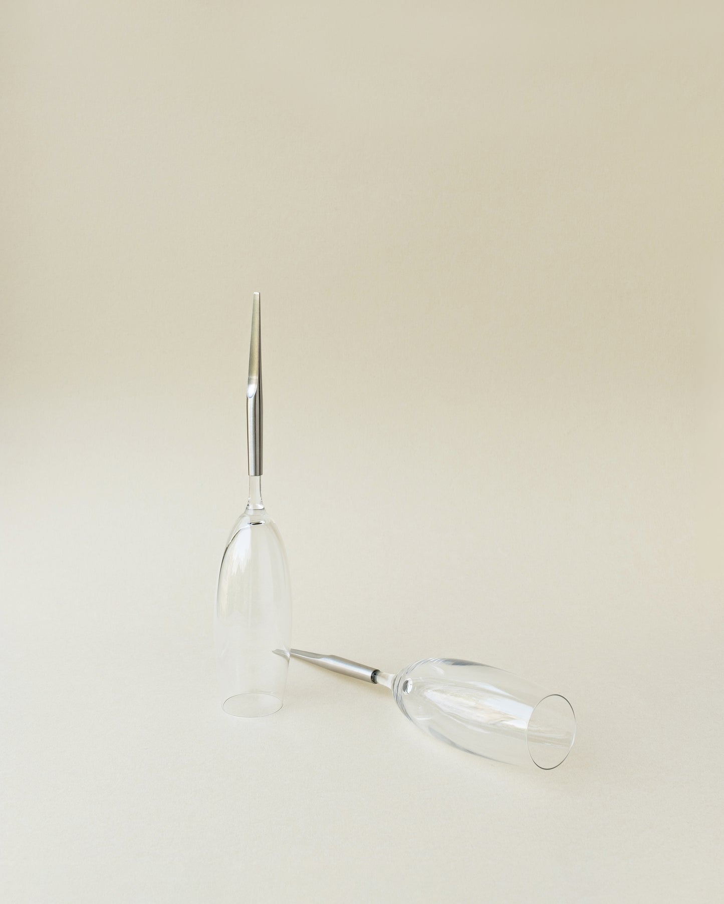 2 Crystal Champagne Glasses with metal Pin, one laying and one standing upside-down