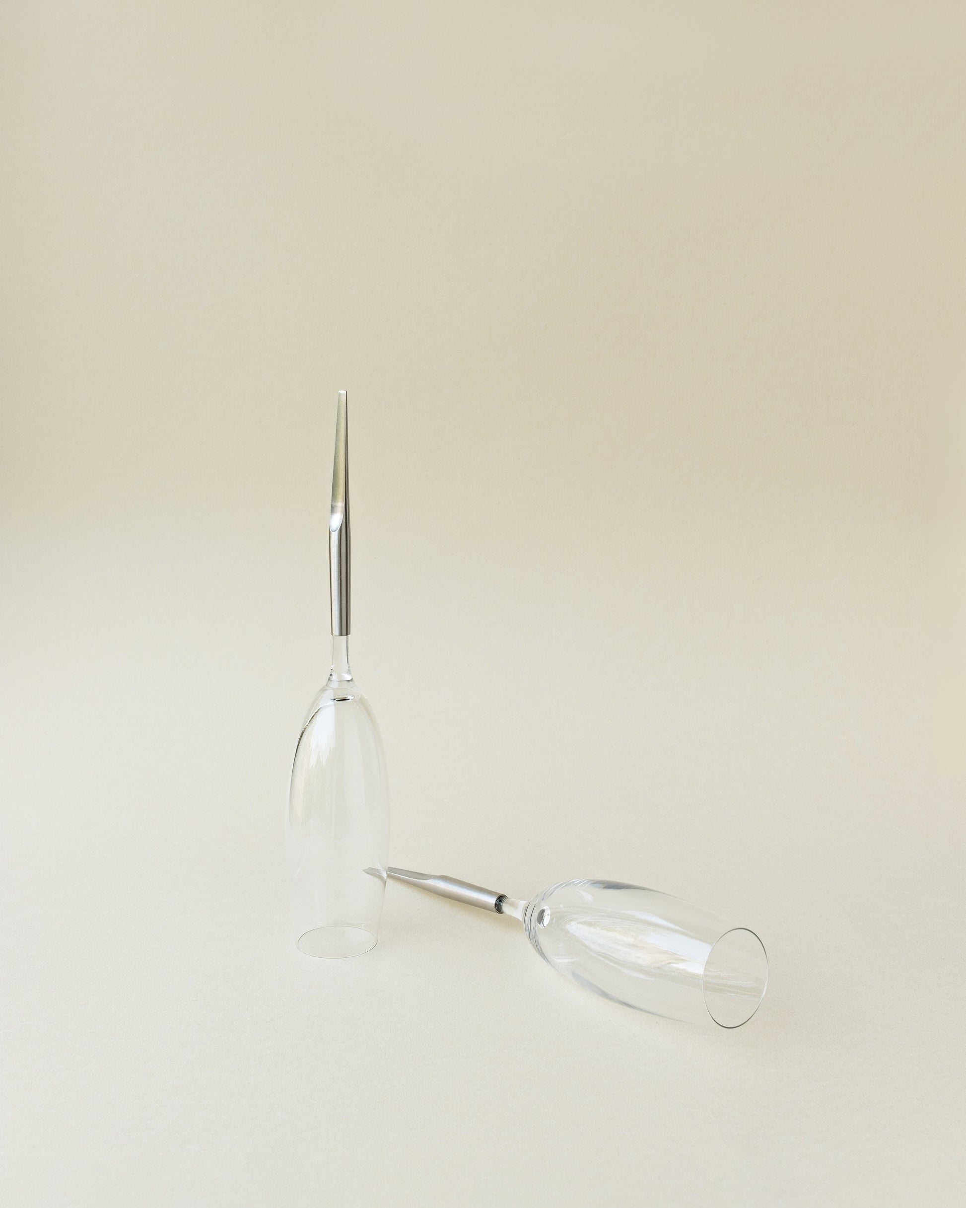 2 Crystal Champagne Glasses with metal Pin, one laying and one standing upside-down