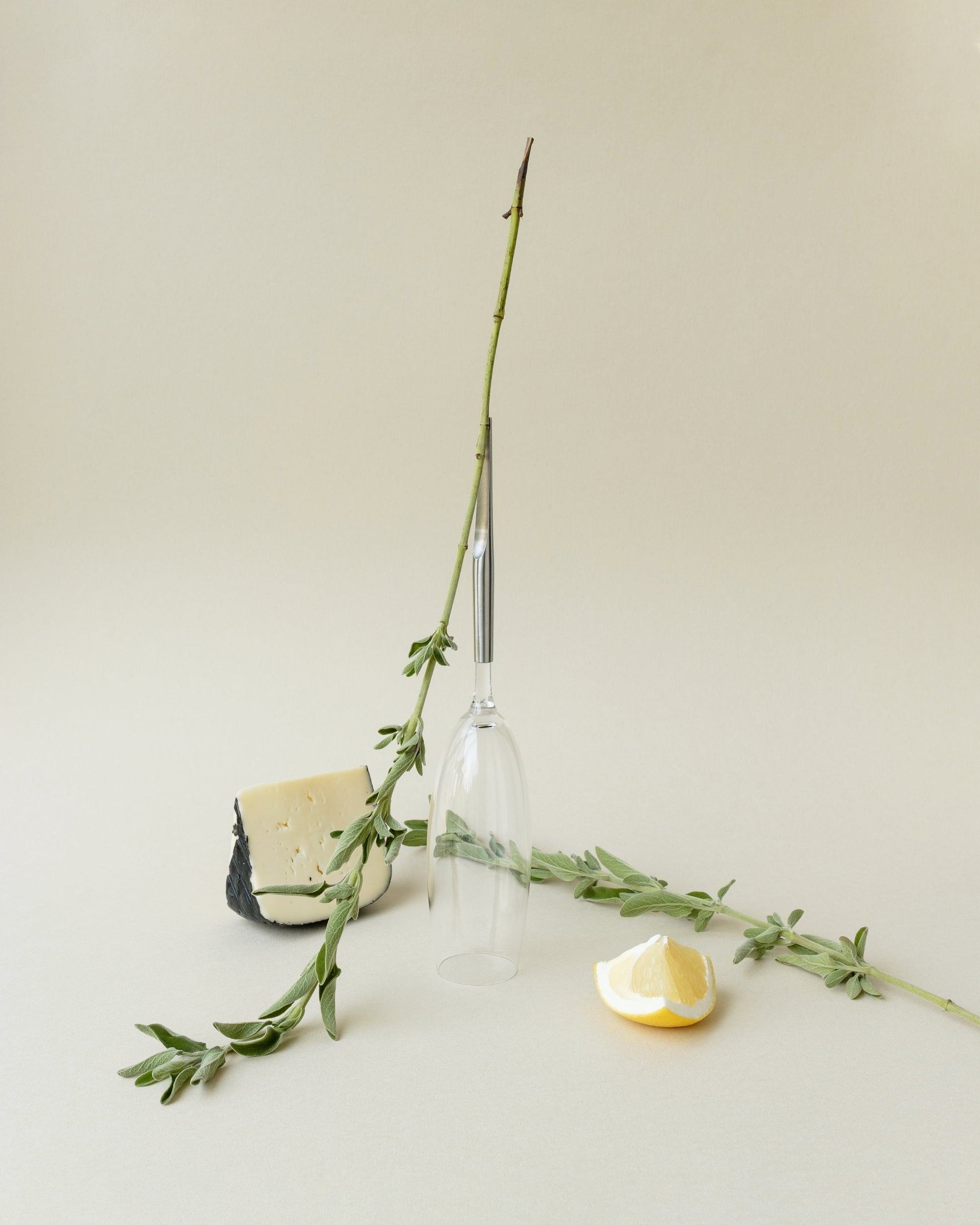 Crystal Champagne Glass with metal Pin standing upside-down, with cheese and cut lemon