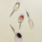 picnic wine glasses with metal pin for white wine, red wine and champagne, placed horizontally on a beige background and half filled with wine