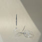 two wine glasses for picnic with metal pin, one upside down and one next to it laying horizontally, with shadows on the background