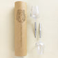 2 picnic wine glasses with metal pin placed horizontally next to their cardboard packing tube for transport