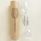 2 picnic wine glasses for red wine laying next to each other and next to cardboard packing tube